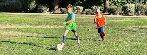 Two children playing soccer